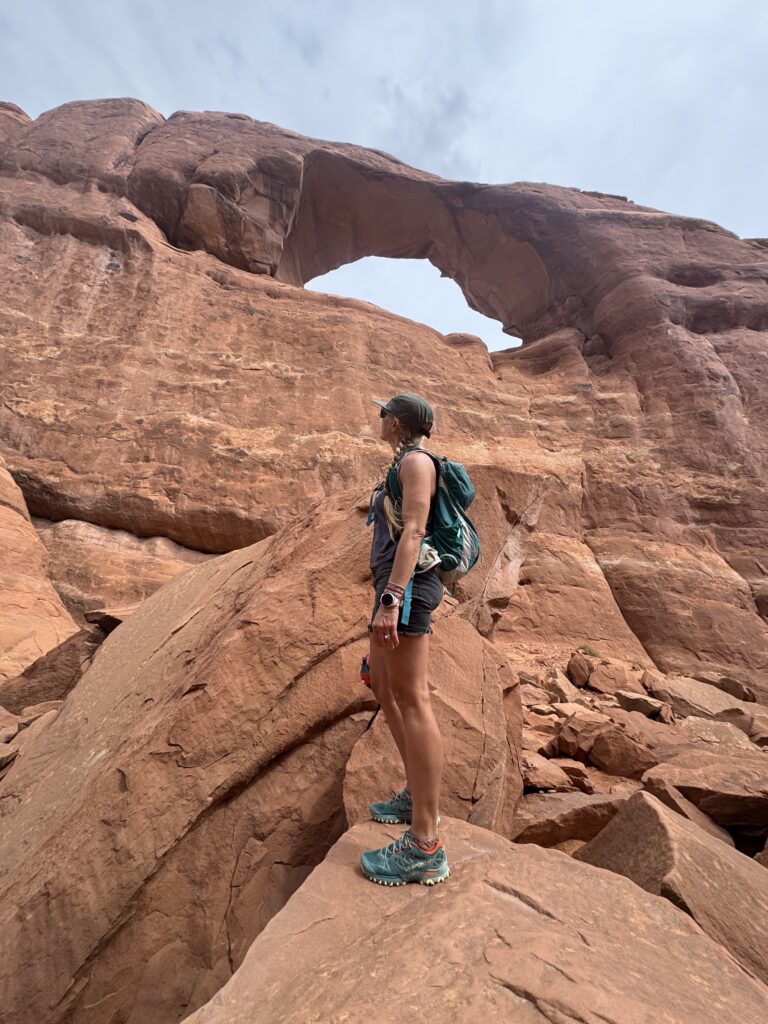 Woman admiring an arch in Arches National Park