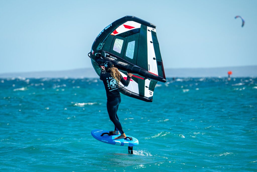 Wing foiling instructor winging in the ocean