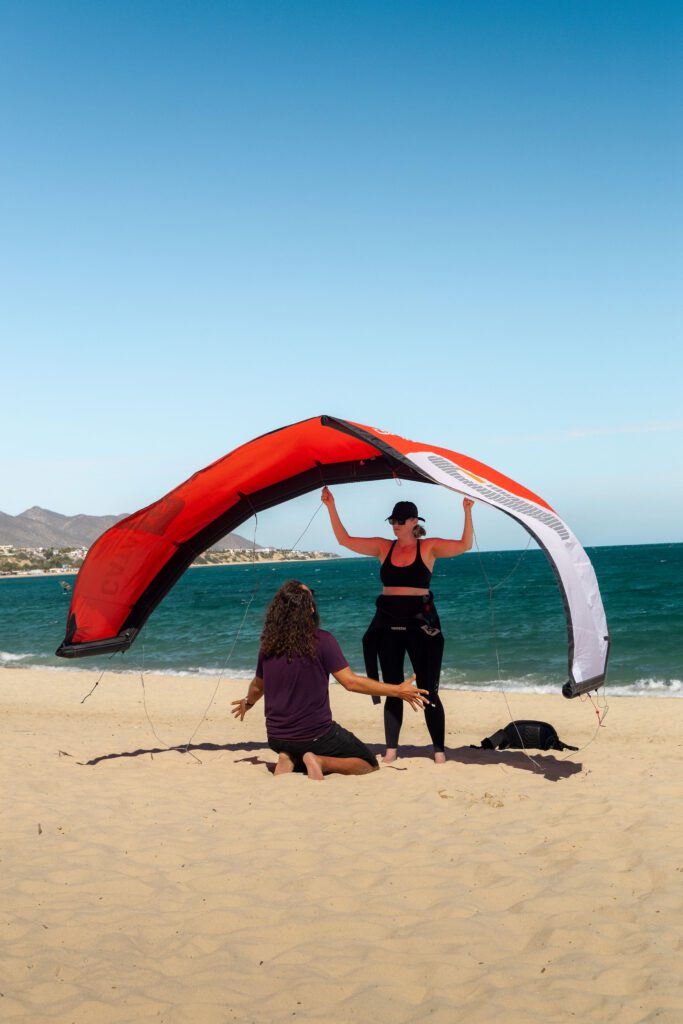 Student and instructor learning basics of the kite on the beach