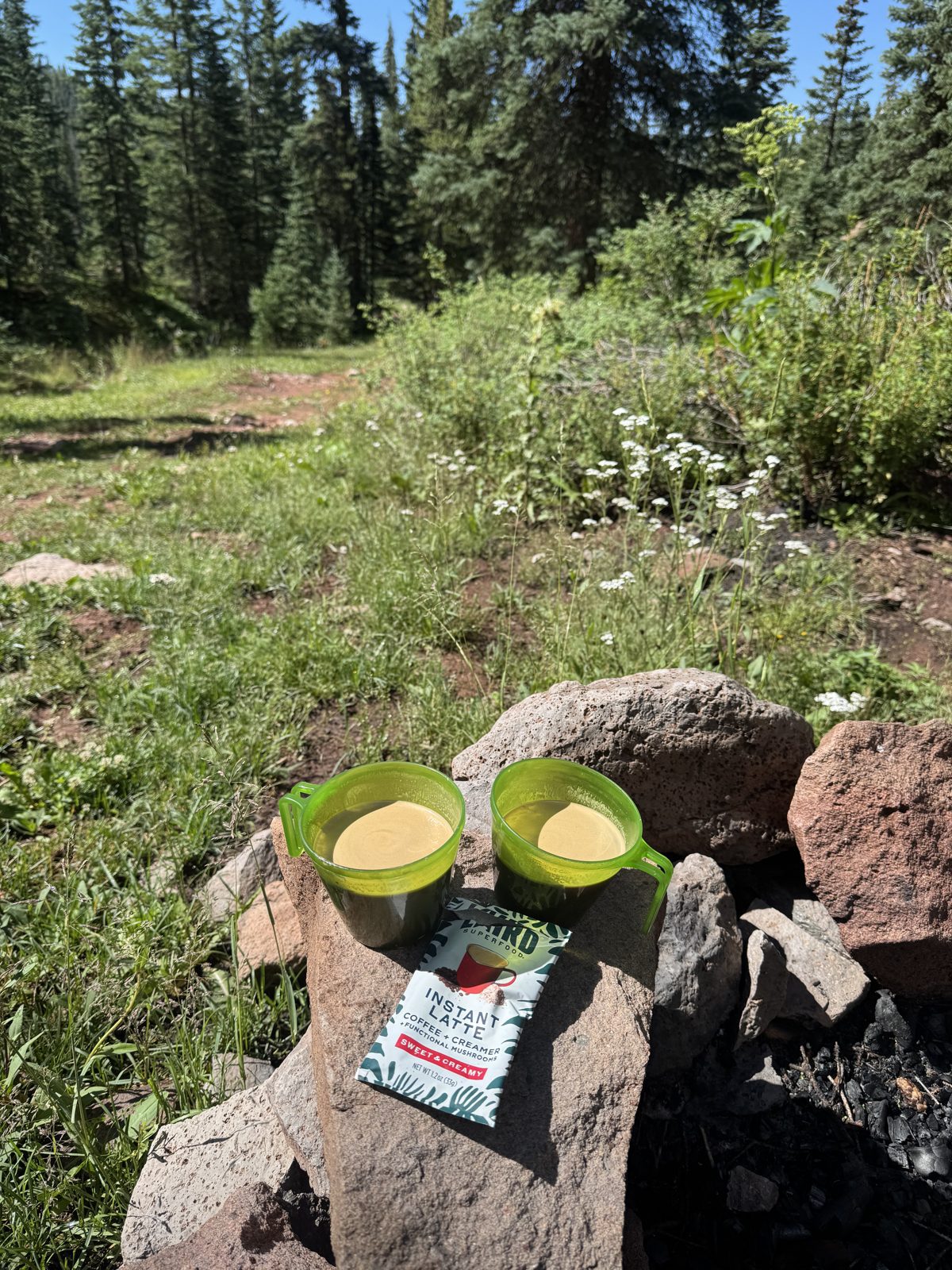 Camper making instant latte coffee at a backcountry campsite in the morning